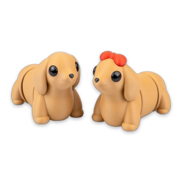 Two tan dachshund figures viewed from the side, showing their poseable jointed legs and floppy ears.