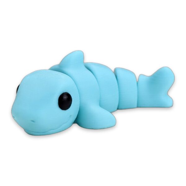 A light blue articulated baby shark figure lying on its side on a white background, with the words Baby Shark beneath it.
