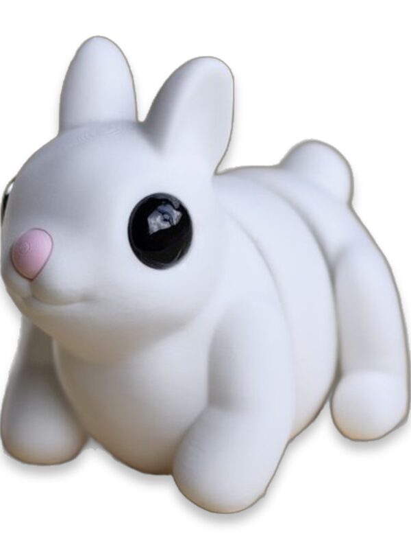 articulated-bunny-fidget-toy-poseable-desk-buddy-1 White articulated bunny figure sitting with ears up and head turned, showing its segmented poseable body.