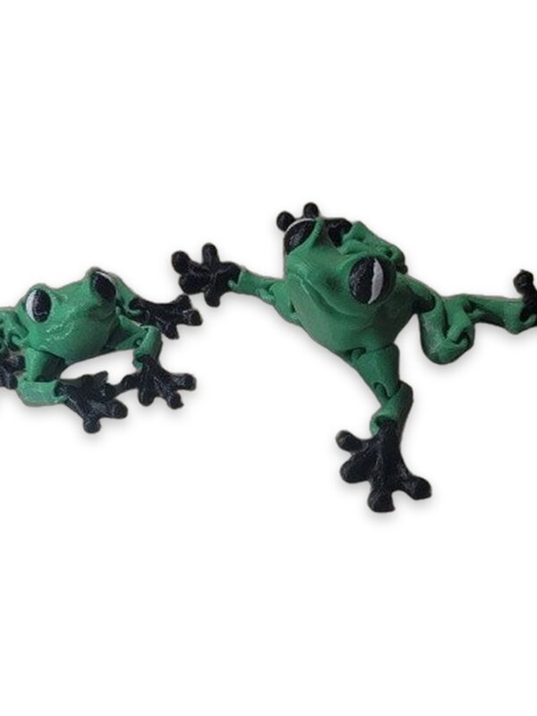 Two small green articulated frog figurines with black painted feet posed on a marble countertop.