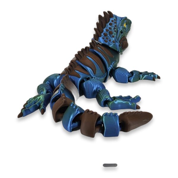articulated-iguana-3d-printed-2 Blue and brown articulated iguana figure shown from above with tail coiled beneath its body.