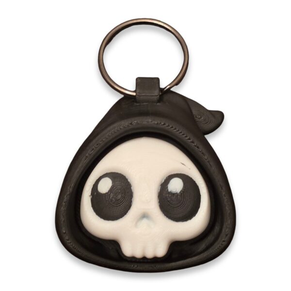 halloween-clickers-fidget-toy-clickable-2 A black hooded skull fidget clicker keychain with large cartoon eyes, shown on a metal split ring.