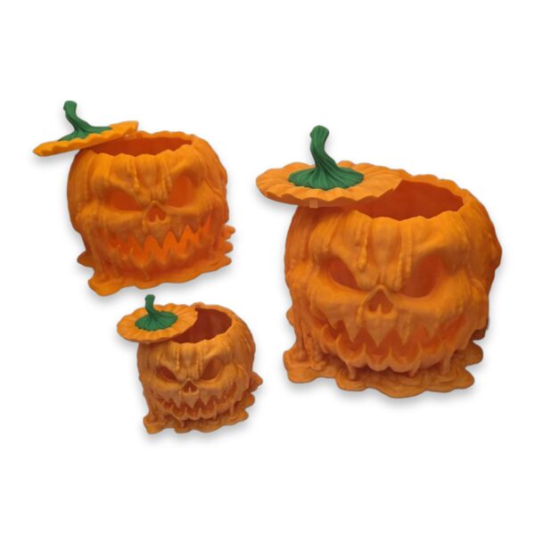 melting-pumpkin-candy-dispenser-3 Three melting pumpkin dispensers shown open with lids removed, revealing hollow interiors for candy